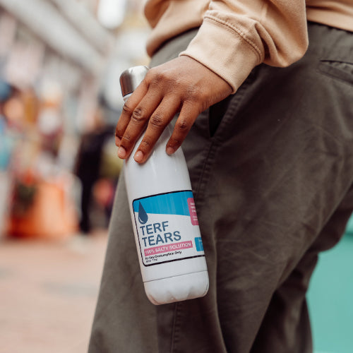 Person holding a bottle labelled 'Terf Tears'