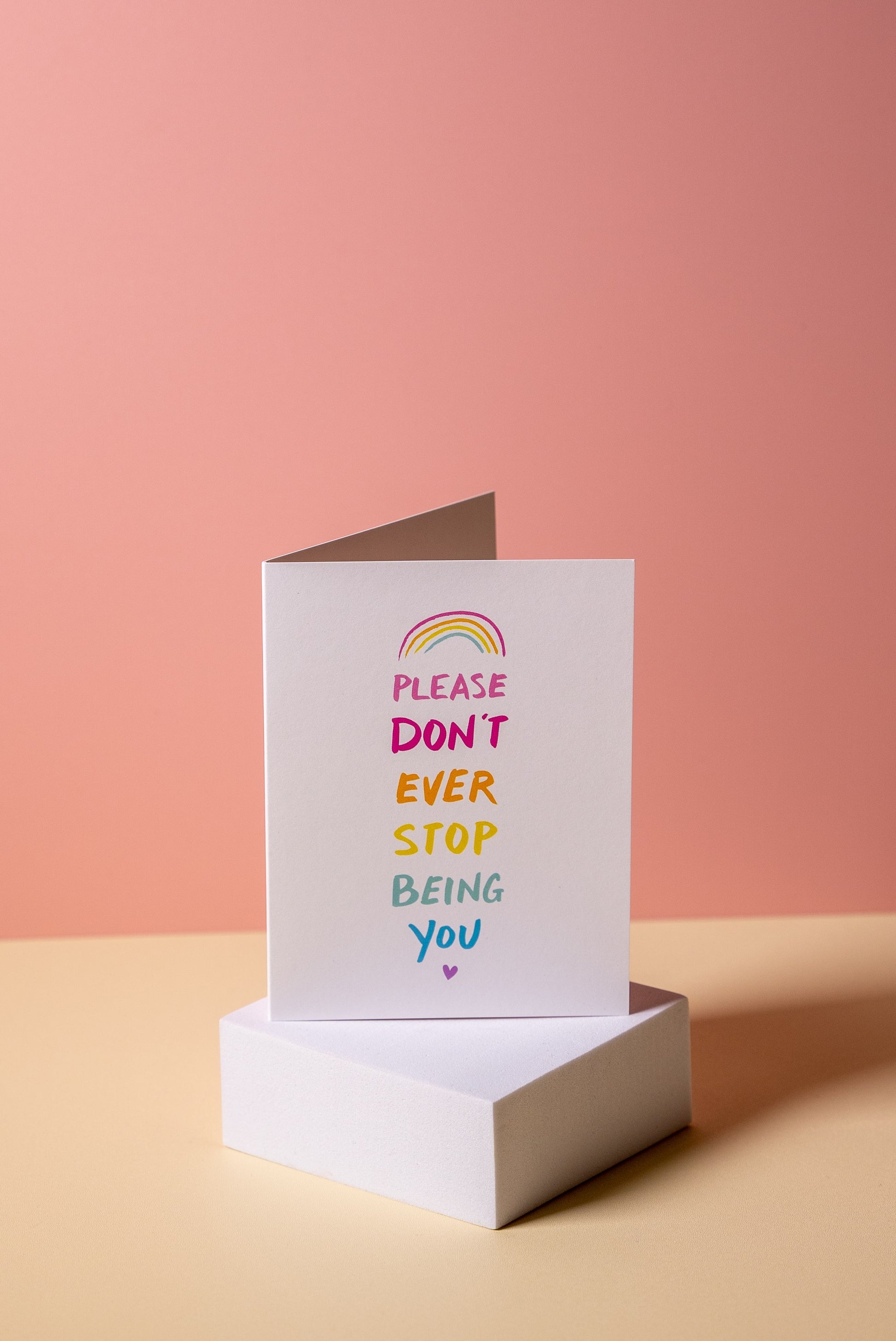 Greeting card with 'please dont ever stip being you' message on a pink and beige background
