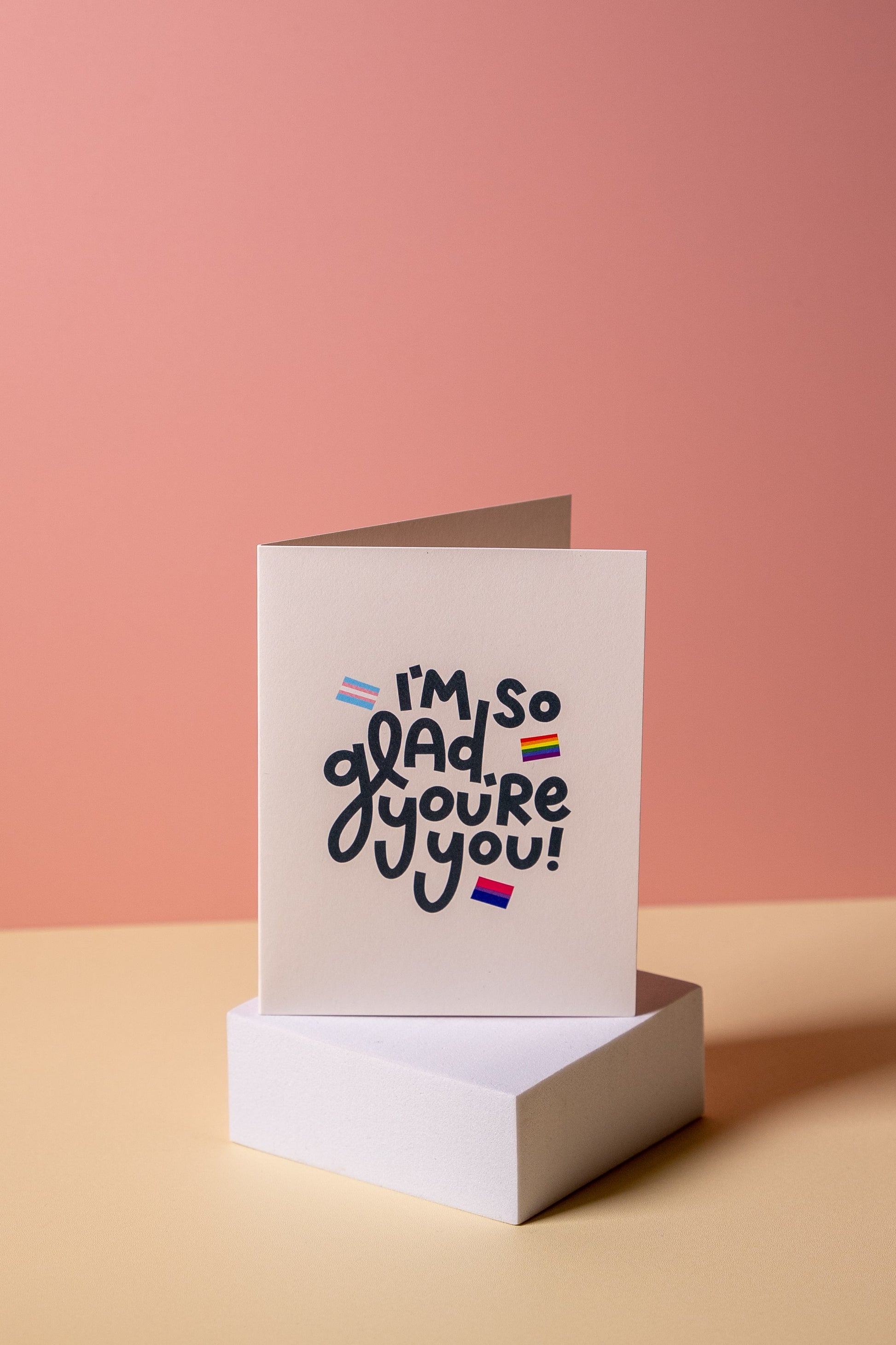 Greeting card with 'I'm so glad you're you' text on a pink background
