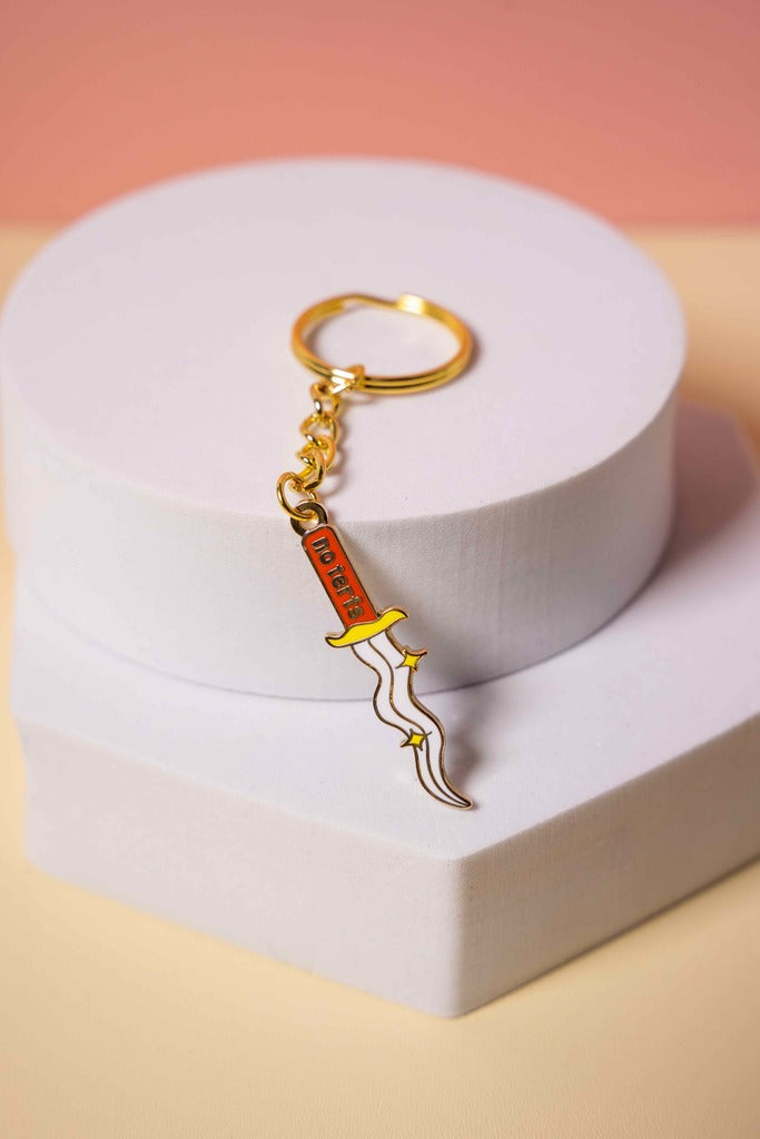 No Terfs keychain shaped like a sword on a white heart-shaped stand with a pink background