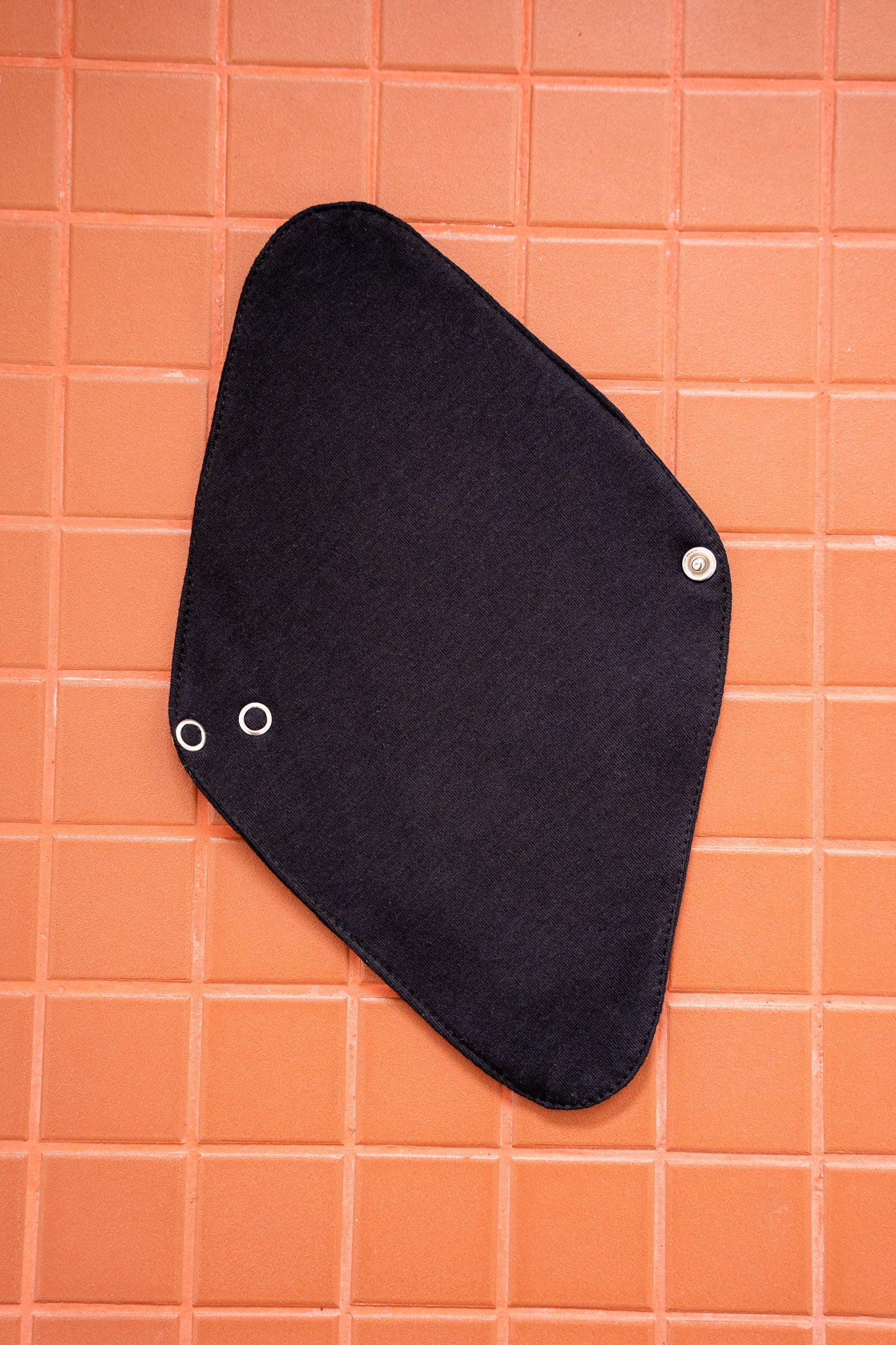 Black cloth pad on an orange tiled background