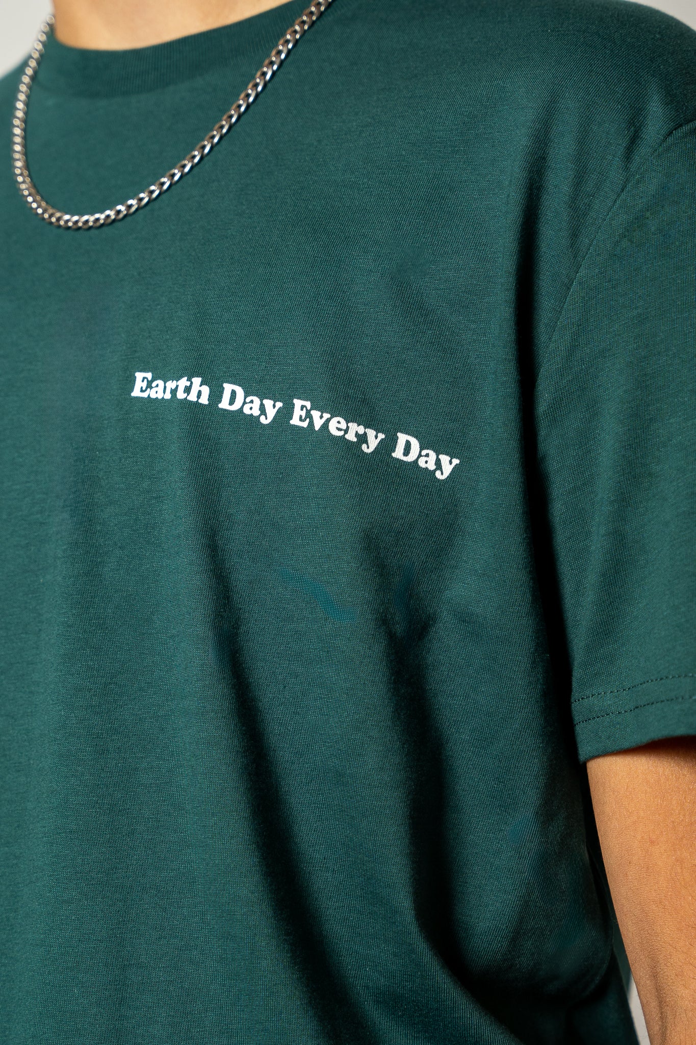 Green t-shirt with 'Earth Day Every Day' text worn by a person